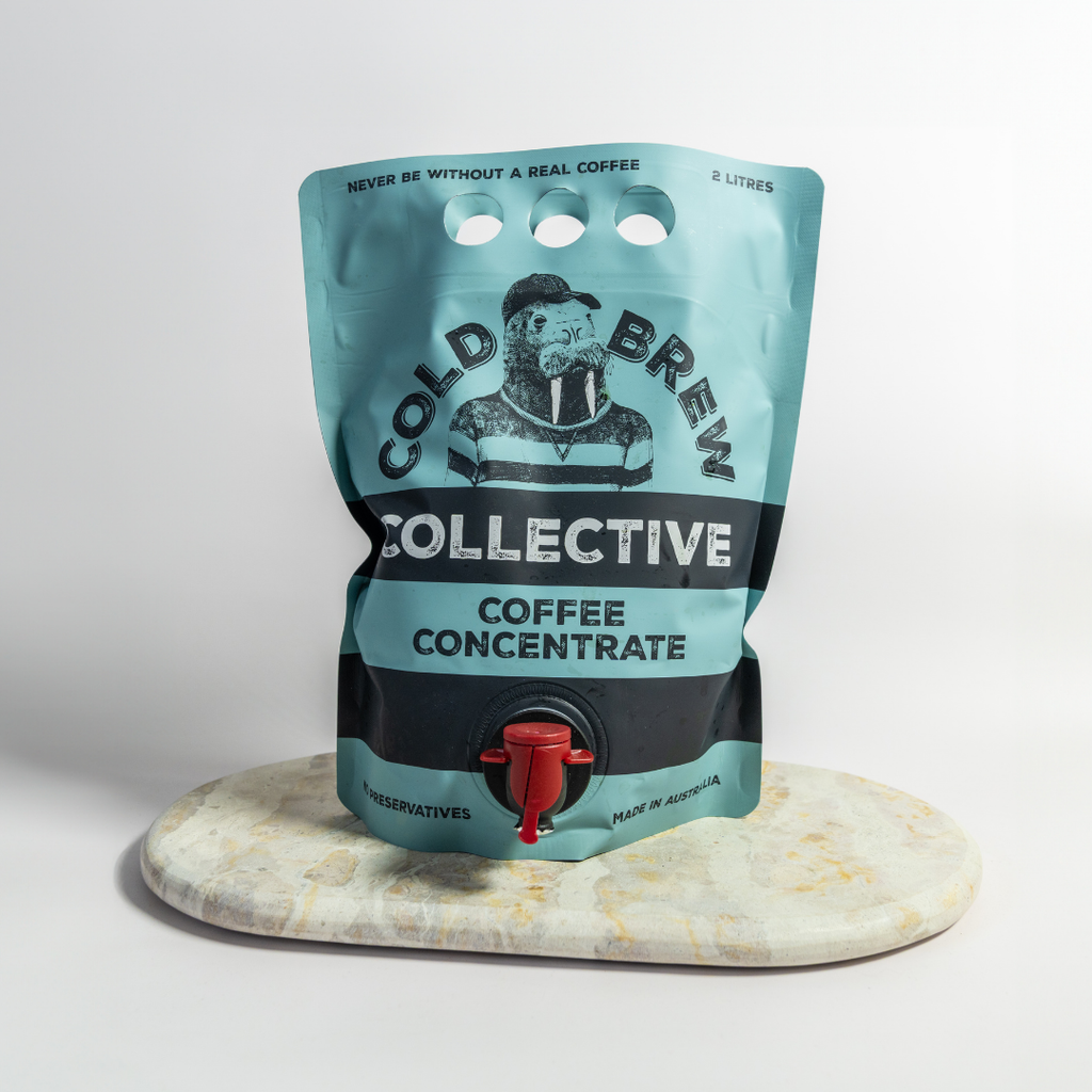 Cold Brew Collective coffee concentrate pouch on a marble coaster with a light gray background