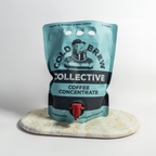 Cold Brew Collective coffee concentrate pouch on a marble coaster with a light gray background