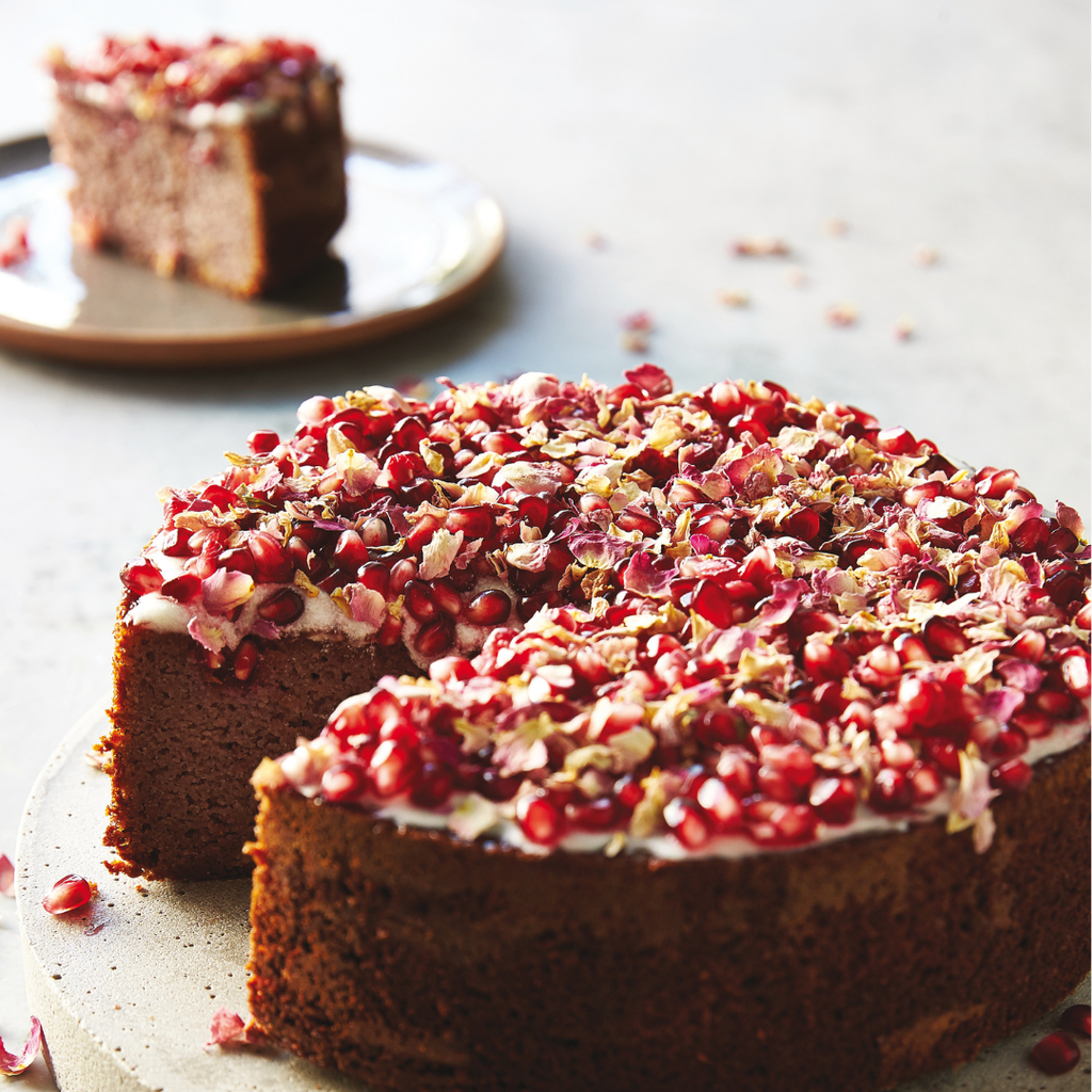 Pomegranate cake with a slice taken out on a light background