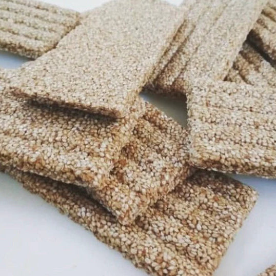 Close-up of sesame seed-covered snacks on a white surface