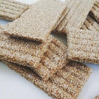Close-up of sesame seed-covered snacks on a white surface
