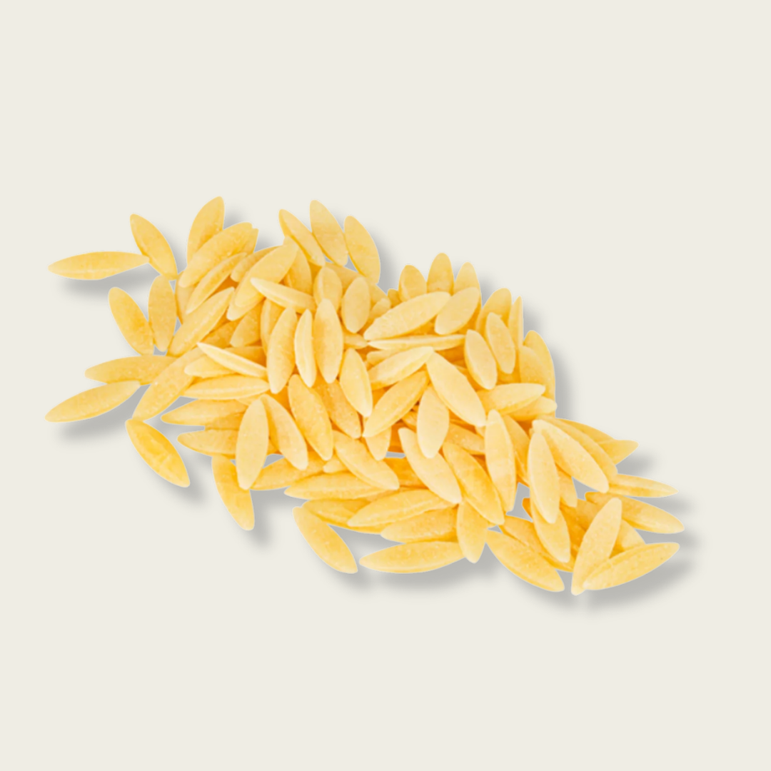Yellow pasta shells on a light gray background