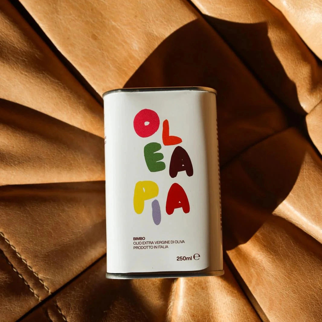 Canister with colorful 'Olea Mia' branding on a brown textured background