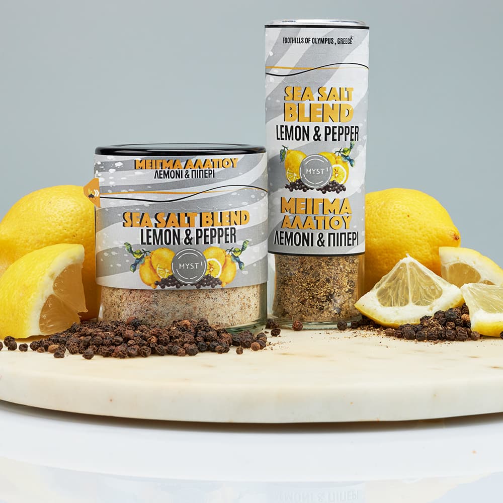 Sea salt blend with lemon and pepper packaging on a wooden board with lemons.