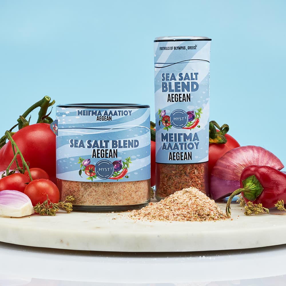 Two containers of 'Sea Salt Blend Aegean' with vegetables on a marble surface