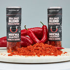 Two cans of sea salt blend smoked paprika with red peppers and paprika powder on a gray background.