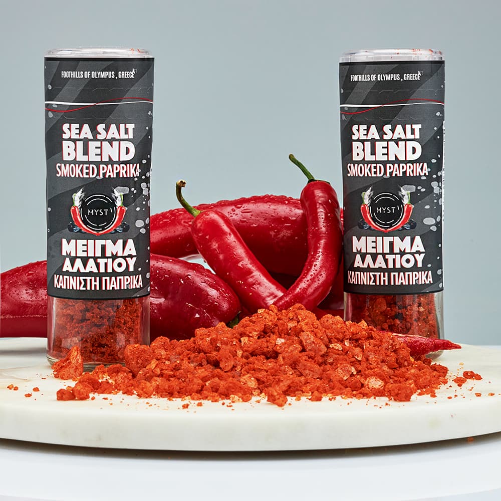Two cans of sea salt blend smoked paprika with red peppers and paprika powder on a gray background.