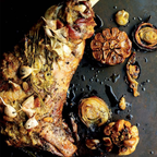 Roasted rabbit with garlic and herbs on a dark surface