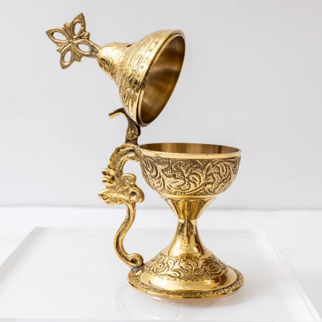 Decorative gold goblet with intricate designs on a white background