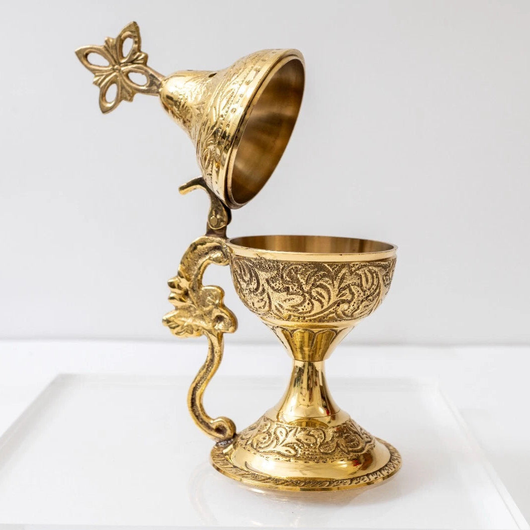 Decorative gold goblet with intricate designs on a white background