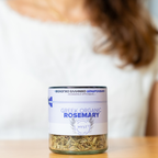 Jar of Greek organic rosemary with a blurred person in the background