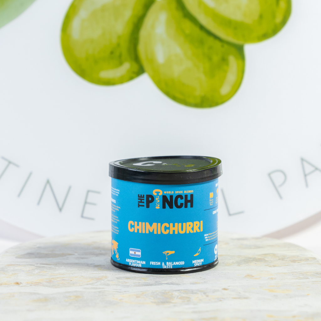 Can of 'The Punch' Chimichurri on a light surface with green slices in the background