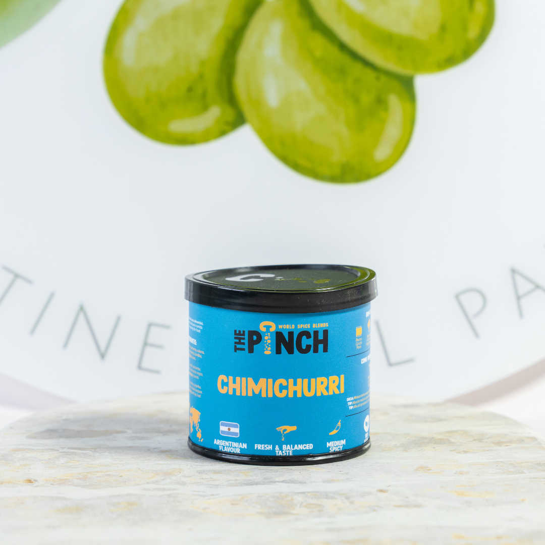 Can of 'The Punch' Chimichurri on a light surface with green slices in the background