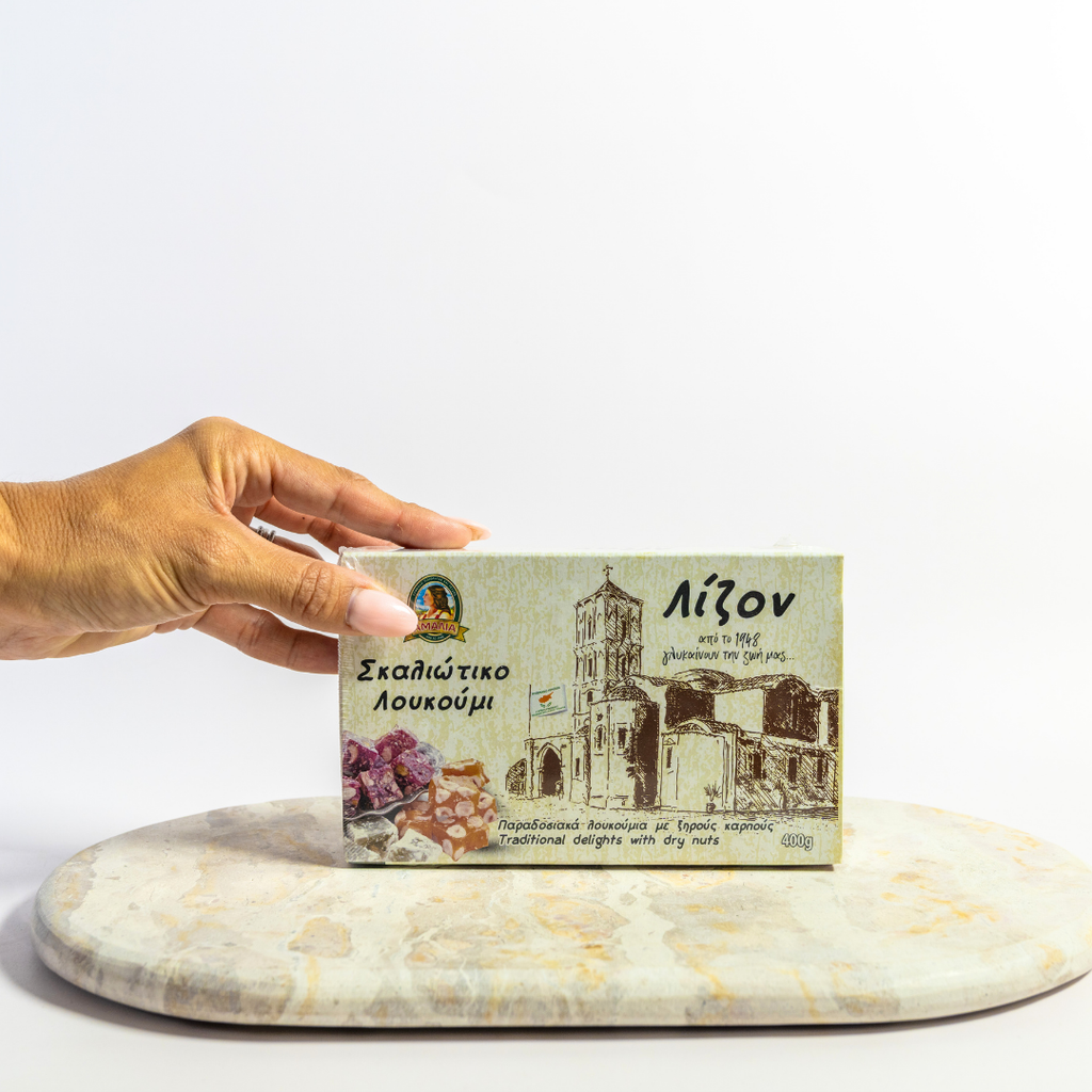 Hand holding a box of turkish greek delight with architectural design on a marble slab