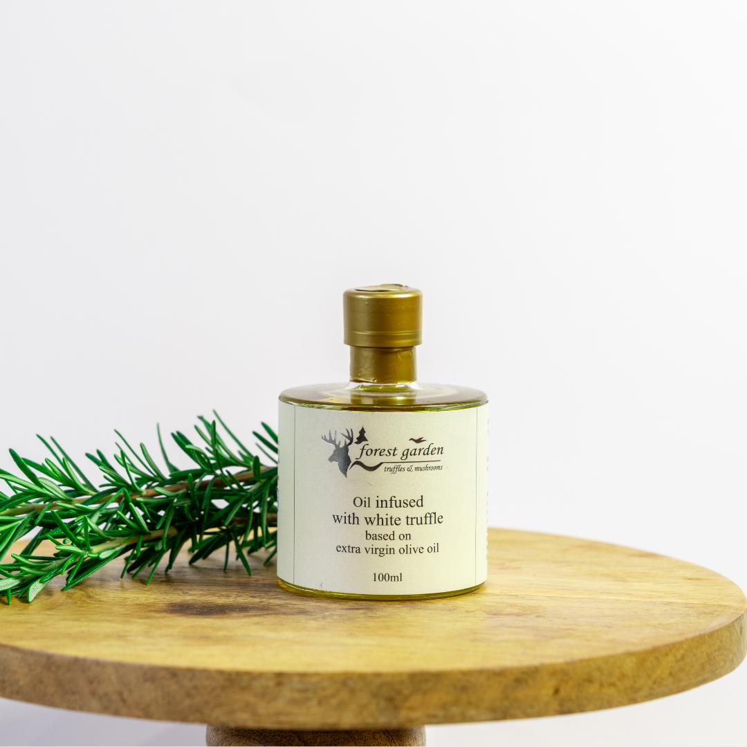 Bottle of oil infused with white truffle on a wooden surface with a white background
