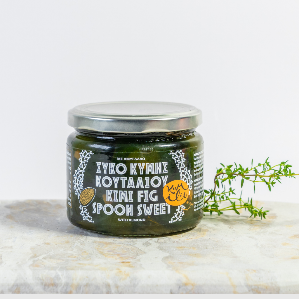 Jar of Kymi Fig Spread on a marble surface with a sprig of thyme.