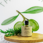 Bottle of Forest Garden olive oil with green leaves on a wooden surface