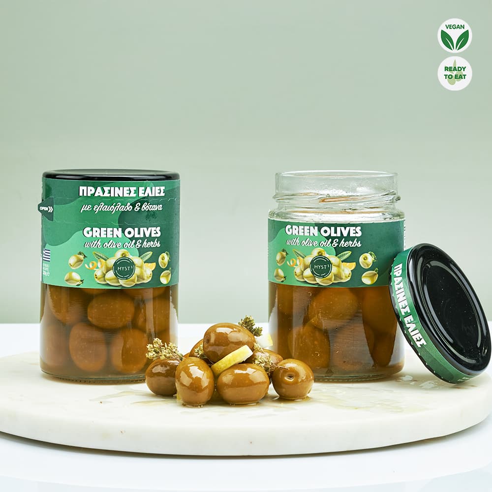 Two jars of green olives with a label on a white surface