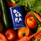 Ole pia can among apples and vegetables in an orange mesh bag