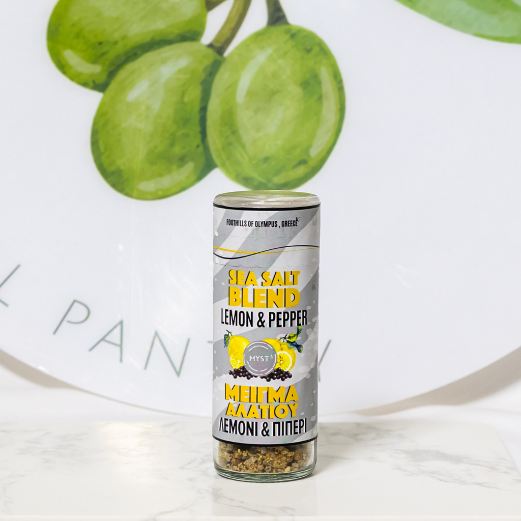 Can of sea salt blend with lemon and pepper flavor on a white surface with green grapes in the background.