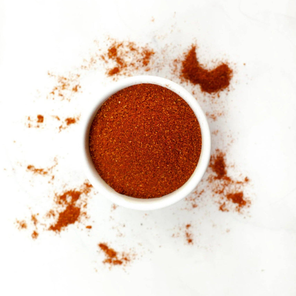 Small white bowl filled with red powder on a white background