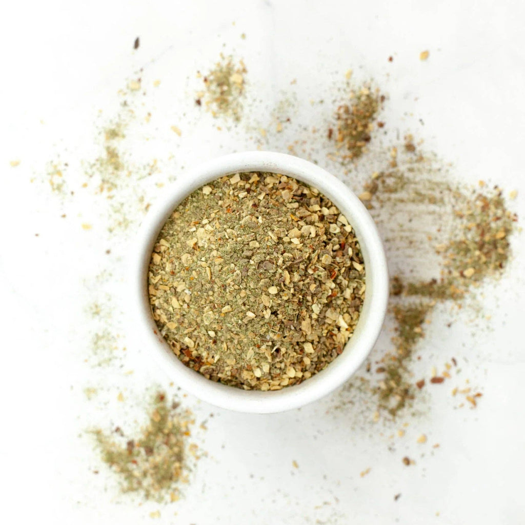 White bowl filled with a spice mix on a white background