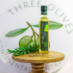 Bottle of Messina white wine vinegar on a wooden stand with green leaves and rosemary, against a branded background.