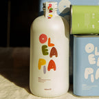 White bottle with colorful 'Olea Pa' branding on a textured surface.