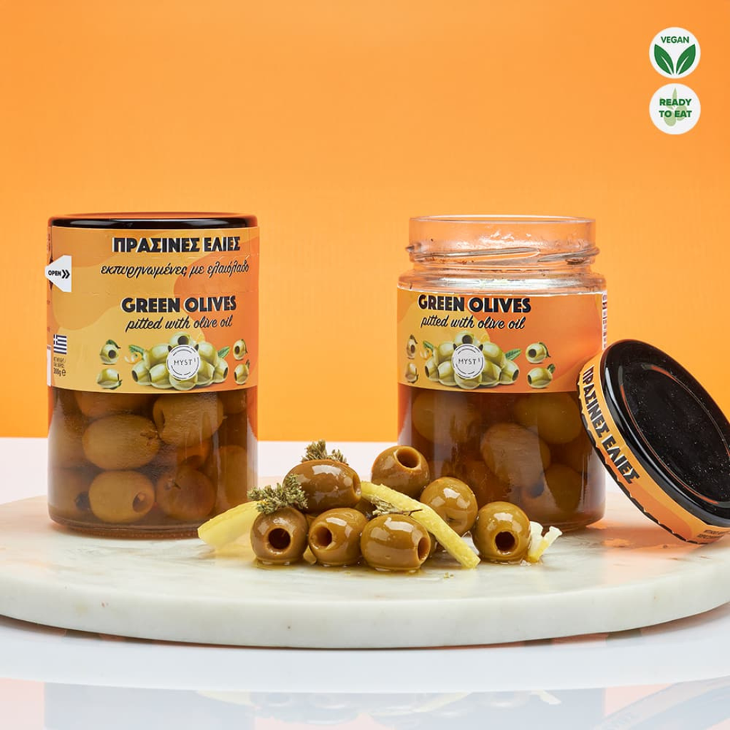 Two jars of green olives with a label on an orange background