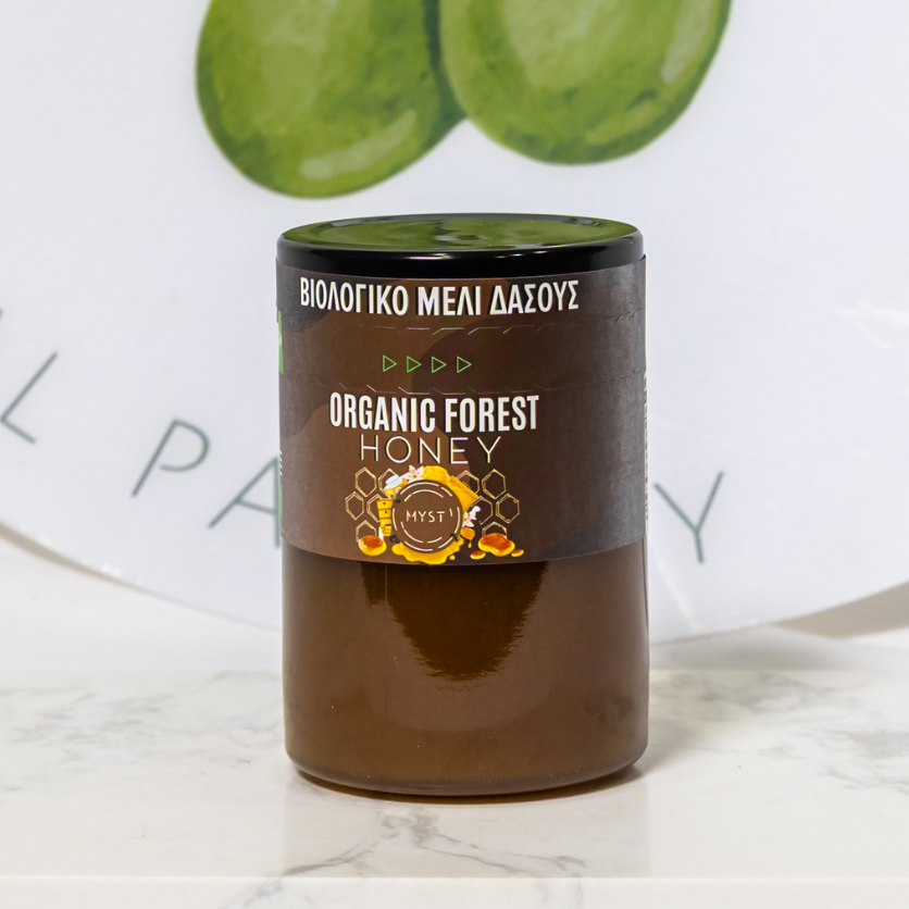 Jar of Organic Forest Honey with a decorative plate in the background