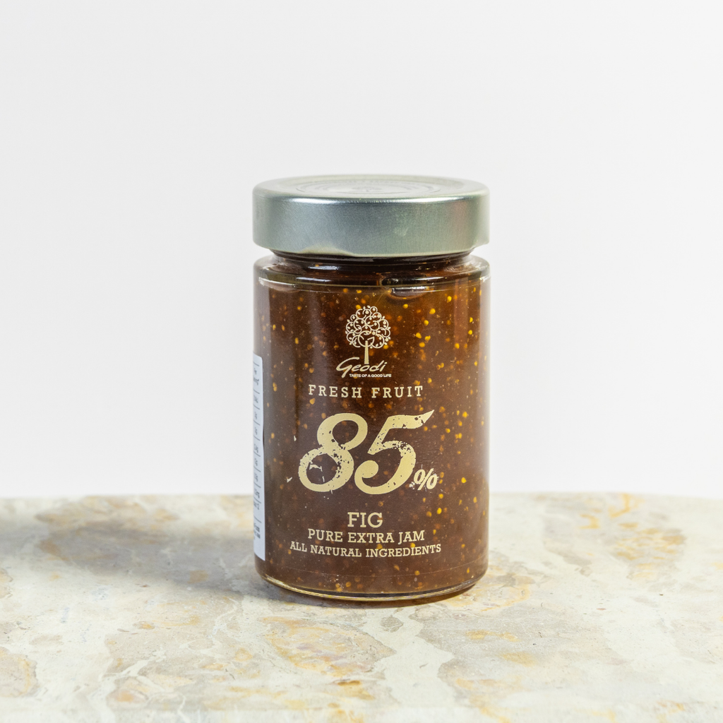 Jar of fig jam with a visible brand logo on a light background