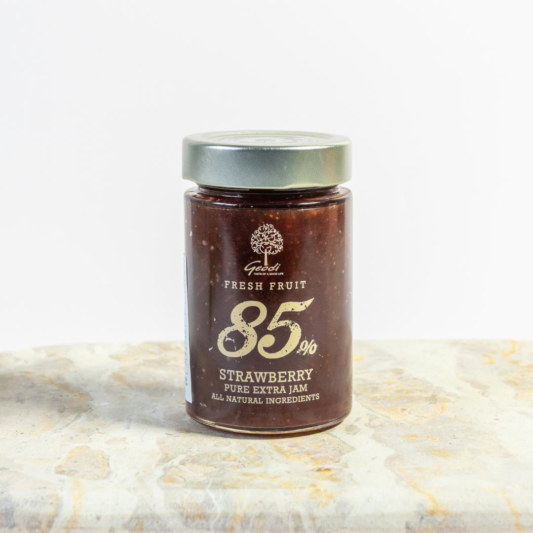Jar of strawberry jam with visible brand name on a textured surface