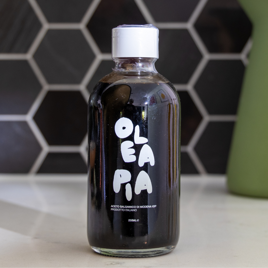 Bottle of Oleapia oil on a kitchen counter with a tiled wall background