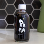 Bottle of Oleapia oil on a kitchen counter with a tiled wall background