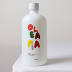 White bottle with colorful 'Olea' branding on a light gray background