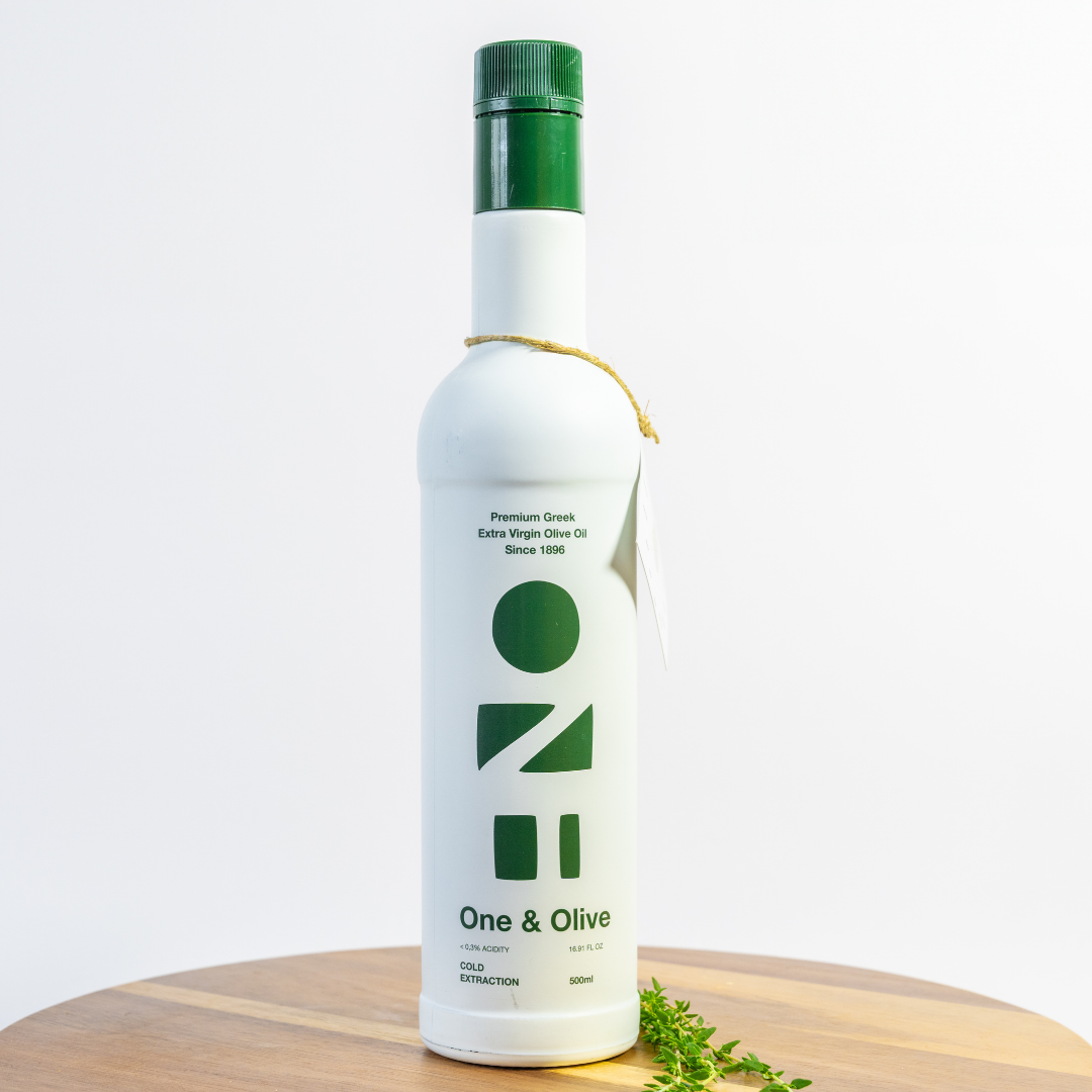 White bottle of olive oil with green cap on a wooden surface and light gray background