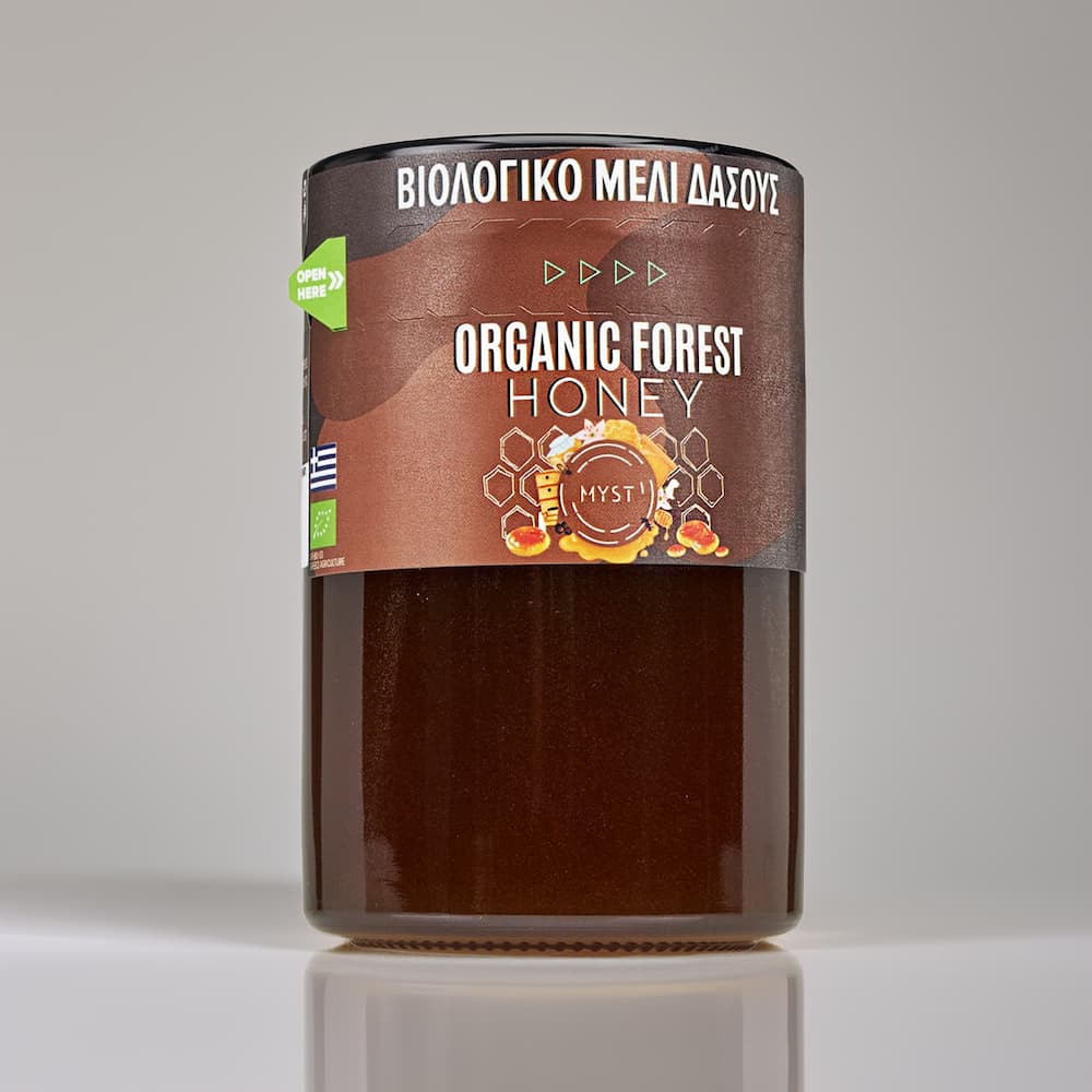Jar of organic forest honey with a label on a gray background