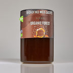 Jar of organic forest honey with a label on a gray background