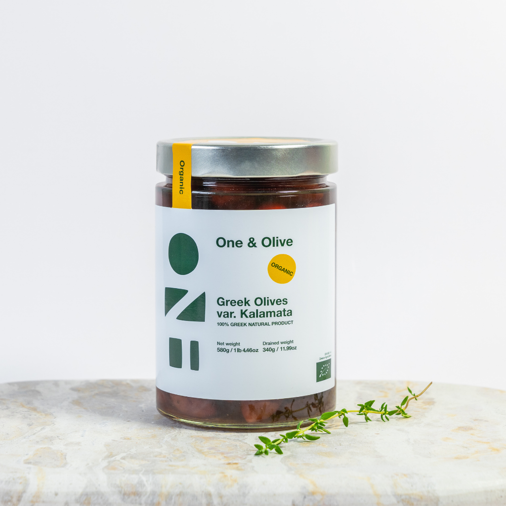 Jar of Greek olives with 'One & Olive' label on a marble surface