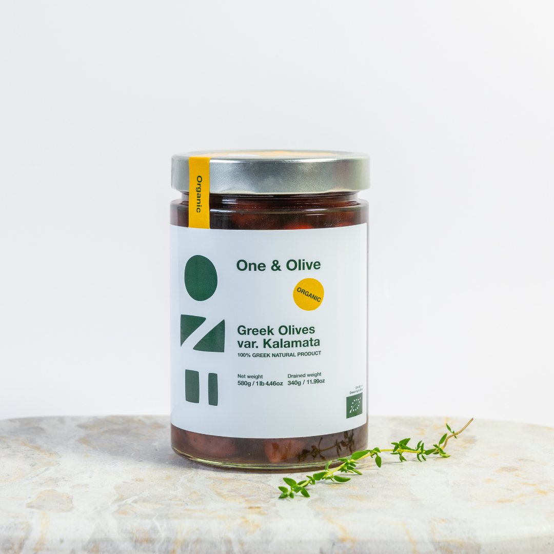 Jar of Greek olives with 'One & Olive' label on a marble surface