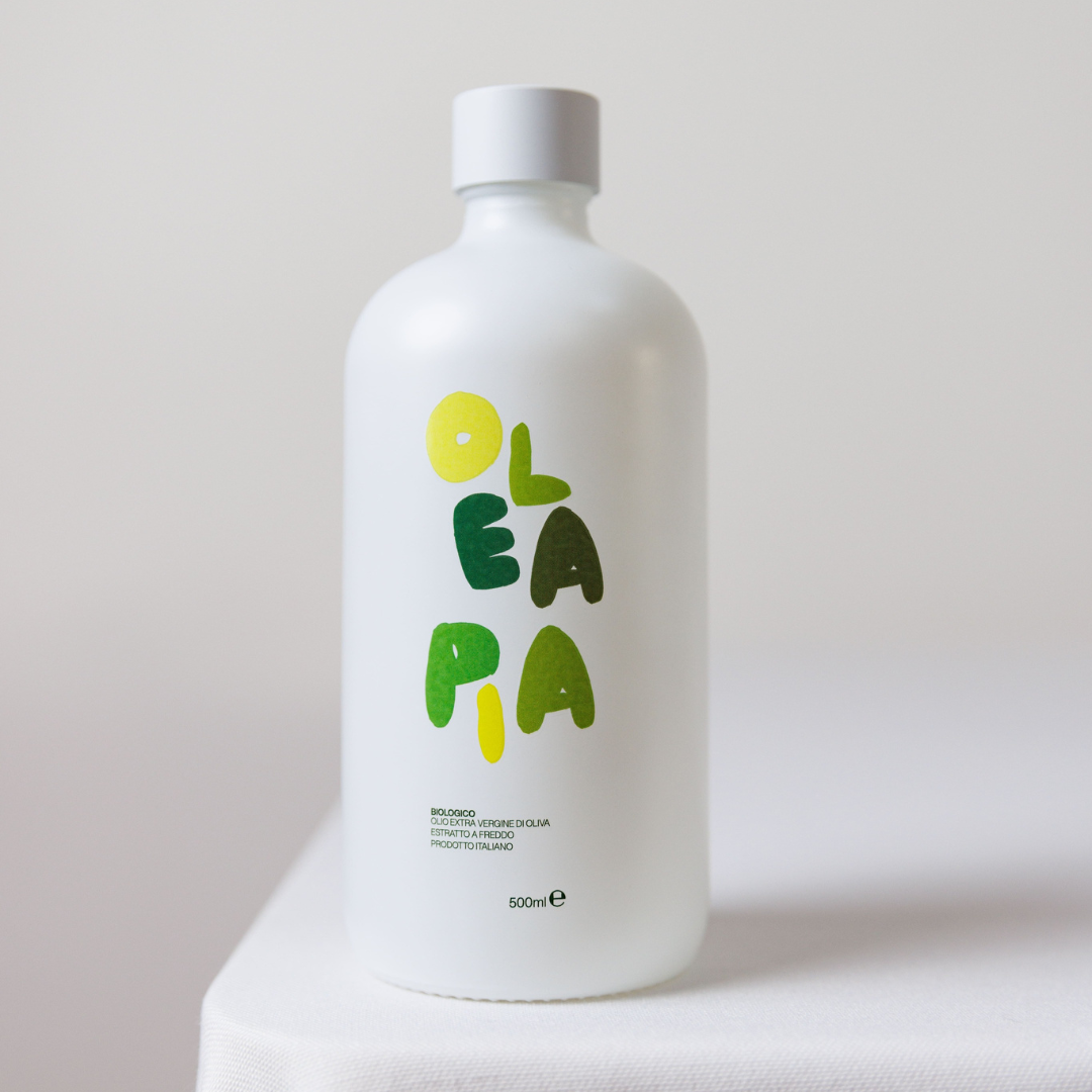 White bottle with green and yellow 'Olea' branding on a light gray background