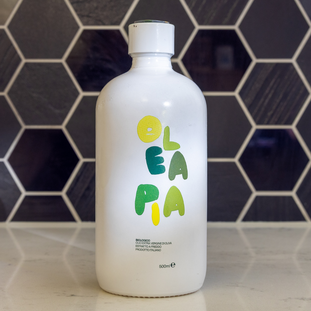 White bottle with colorful text on a tiled wall background