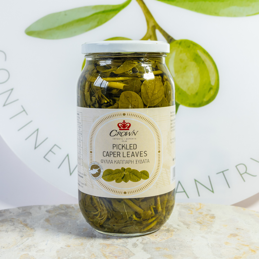 Jar of pickled caper leaves with a label on a light background