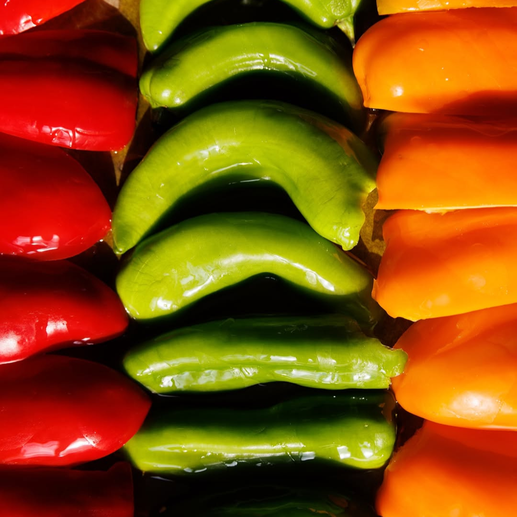 Close-up of sliced red, green, and orange bell peppers.