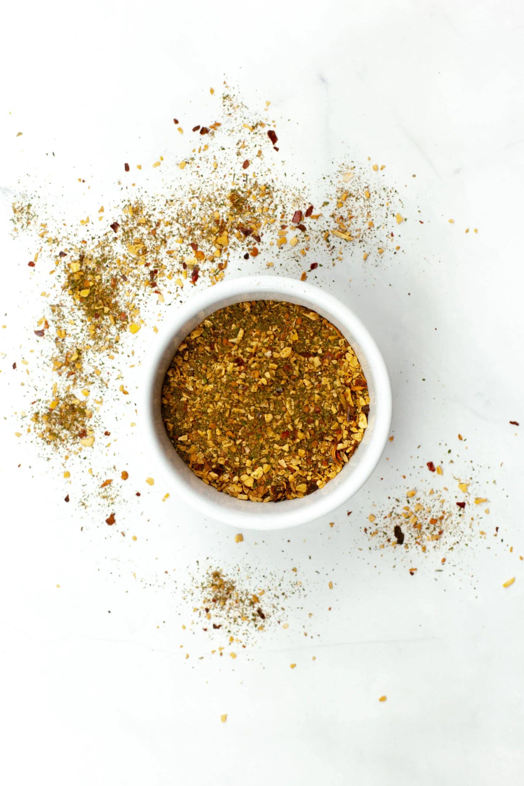 White bowl filled with ground pepper on a white background