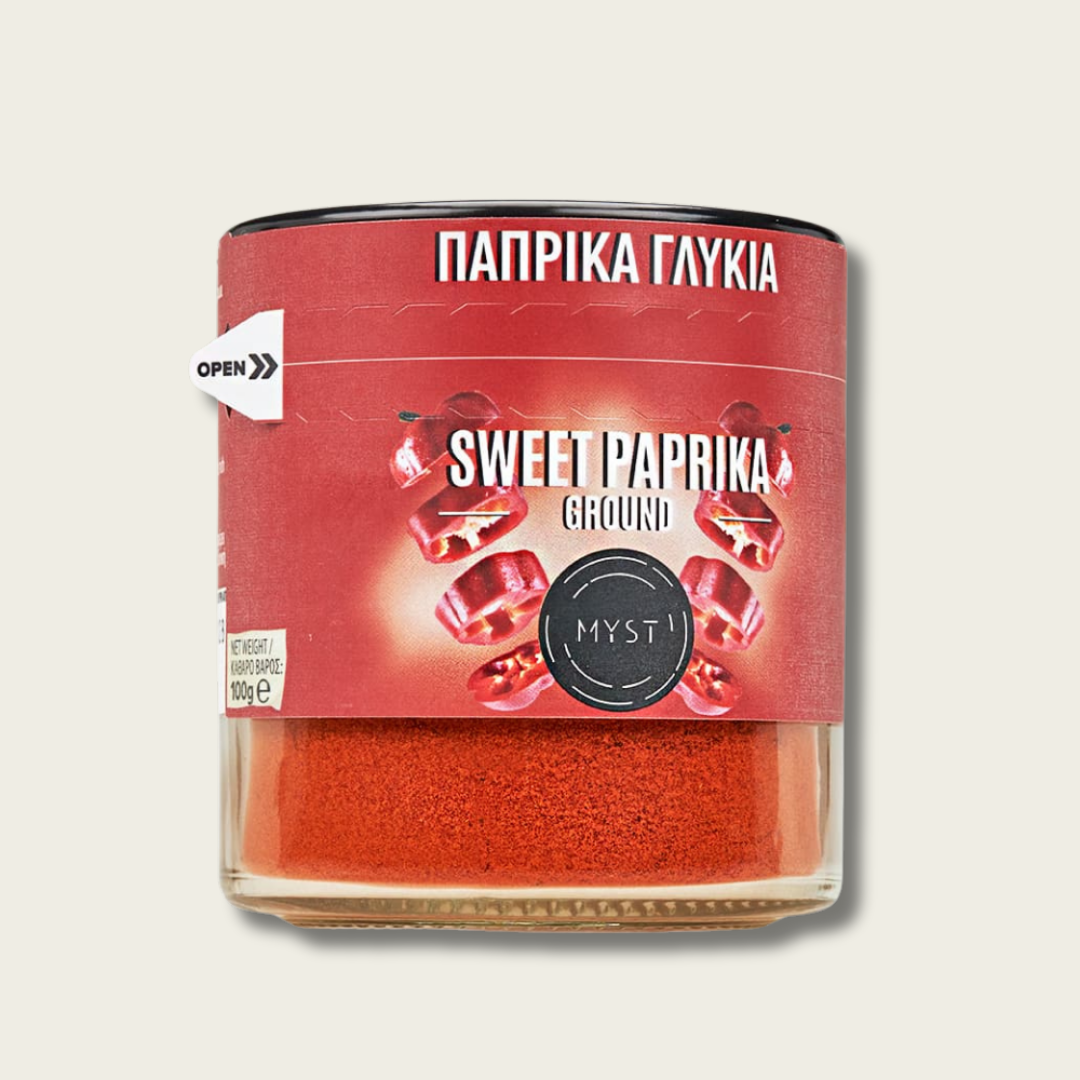 Container of sweet paprika with red label on a light gray background