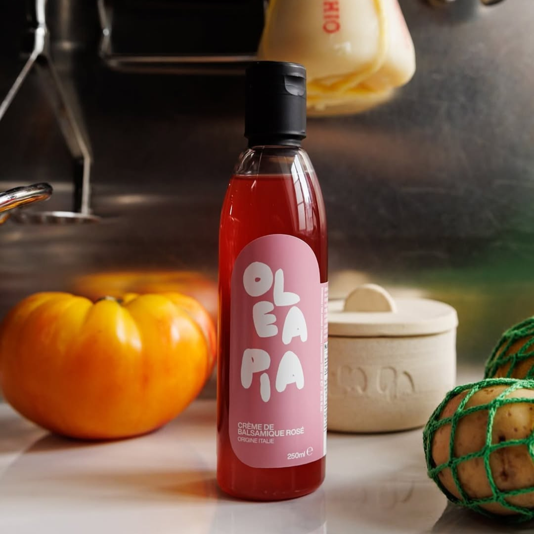 Bottle of Olea Pa on a kitchen counter with pumpkins and kitchen items in the background