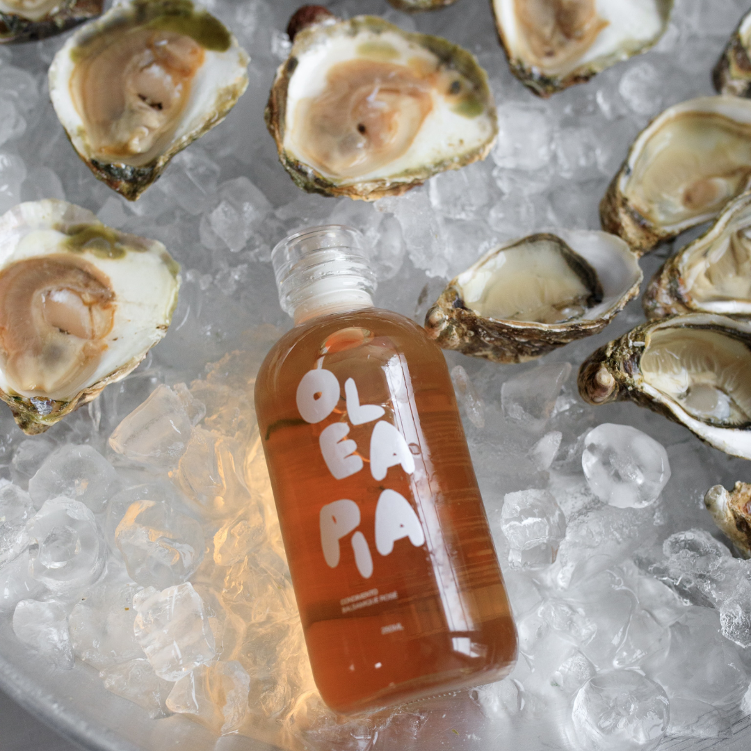 Bottle of Olé Aña on ice with oysters around
