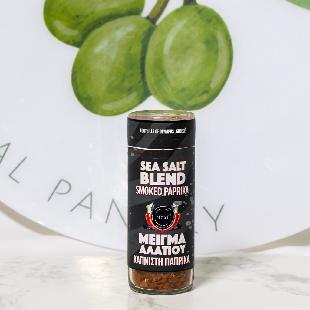 Sea salt blend container with smoked paprika on a white surface with green grapes in the background.