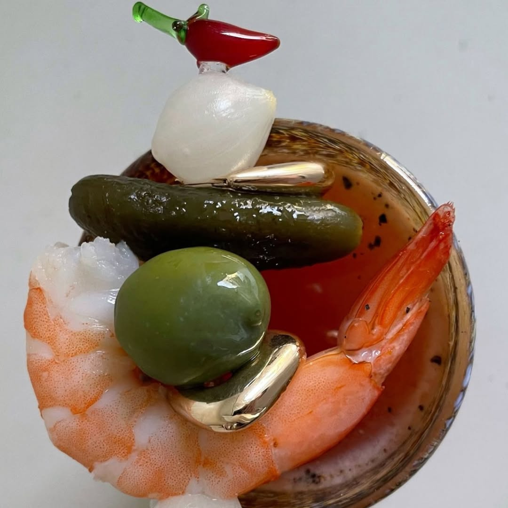 Decorative item with shrimp, pickles, and a red pepper on a white background